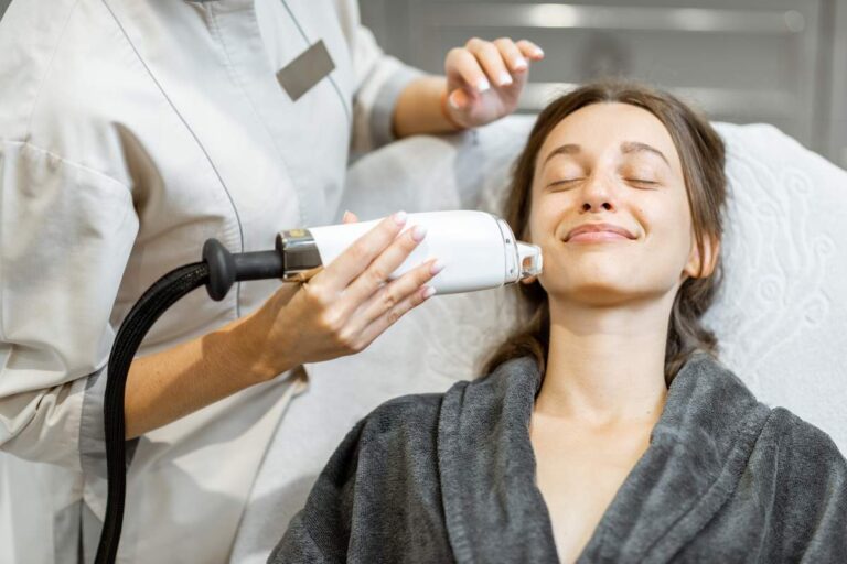 Clinician reviewing a treatment plan with an adult patient beside skincare and procedure diagrams